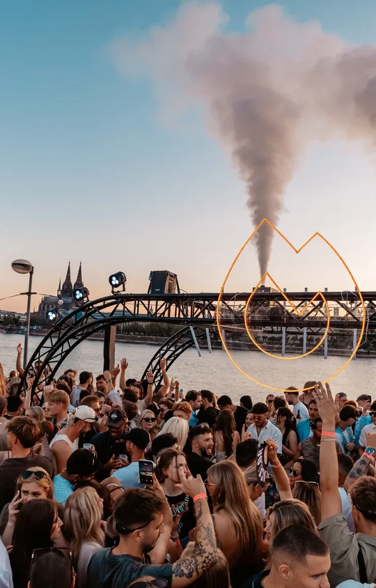 Golden Flame Open Air at the Rheinterrassen in Cologne: the crowd by the Rhine in front of the flame arch
