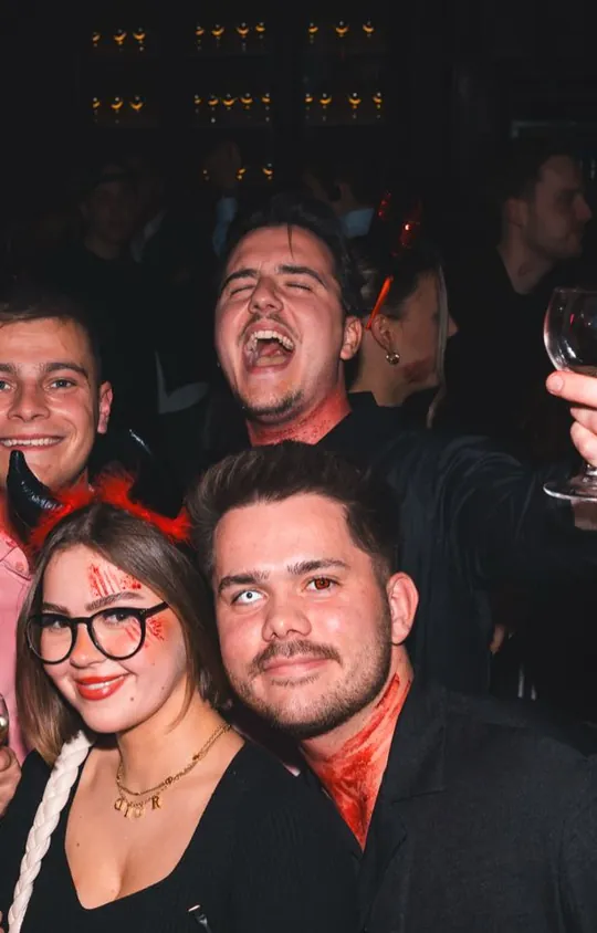 A crew of friends with devil horns and Halloween make-up at Spooky Flame in Cologne, October 2025