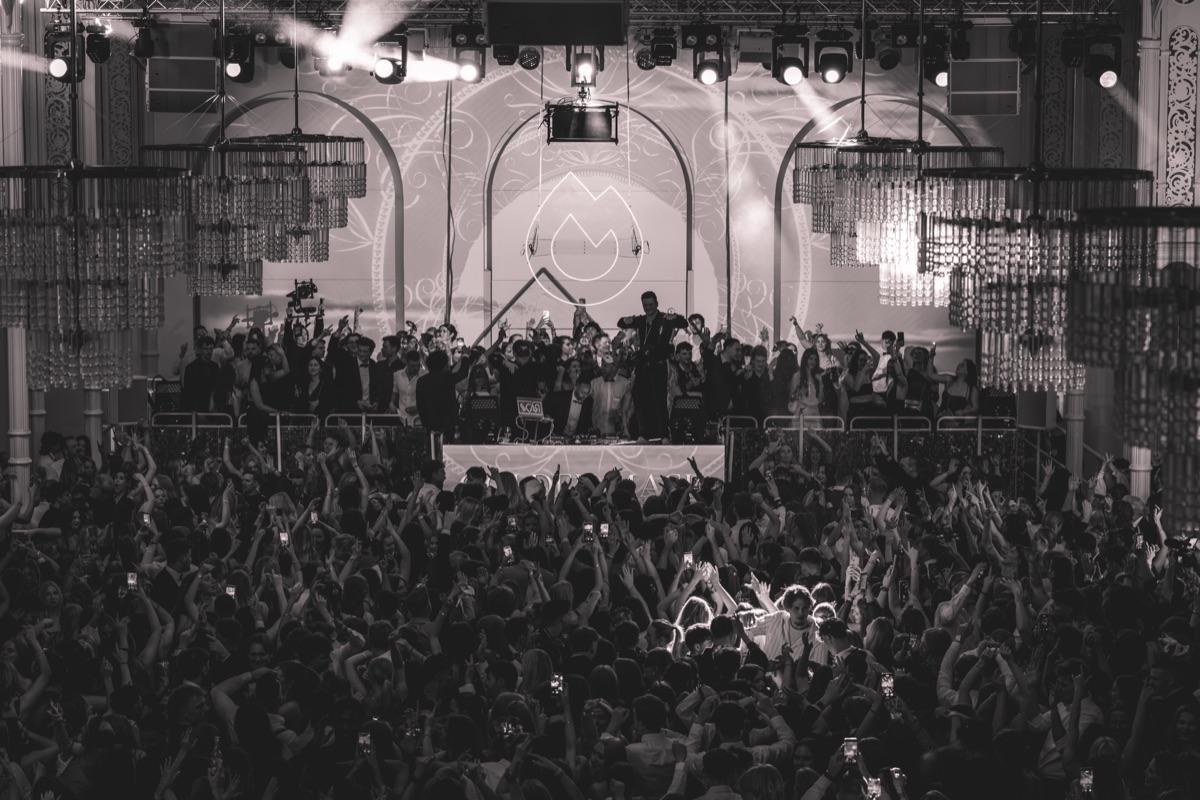 DJ-Pult und Crowd mit erhobenen Händen beim Golden Mask Maskenball in der Flora Köln