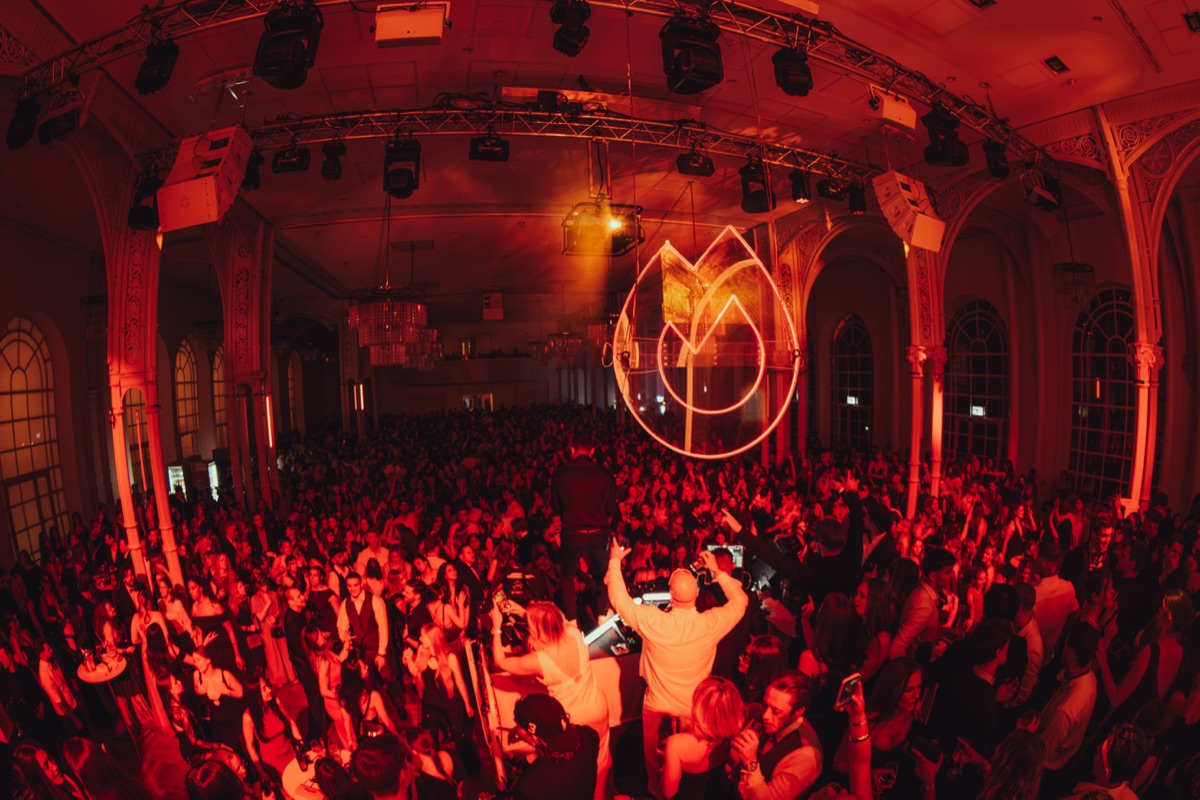 Weite Aufnahme der Halle in rotem Licht mit Crowd beim Maskenball Golden Mask Köln