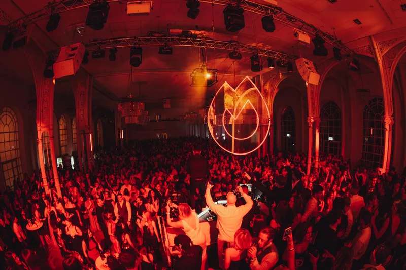 The grand hall of the Flora in Cologne at Golden Mask, bathed in red light and packed to the last row