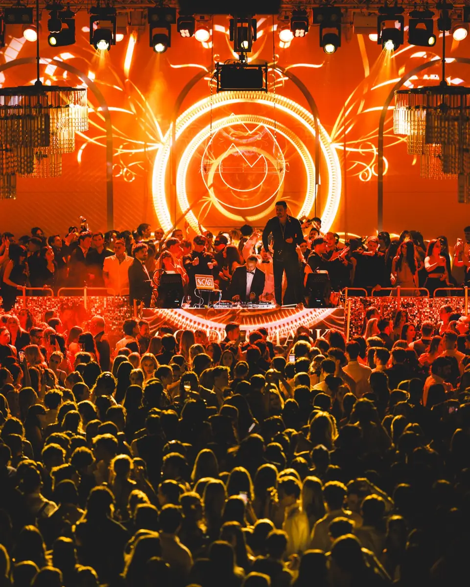 Wide view across the dance floor towards the stage glowing orange at Golden Mask in the Flora, Cologne