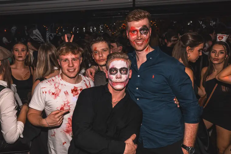 Freunde mit Totenkopf-Make-up, halb geschminktem Gesicht und Kunstblut auf dem weißen Shirt bei Spooky Flame 2024 in Köln