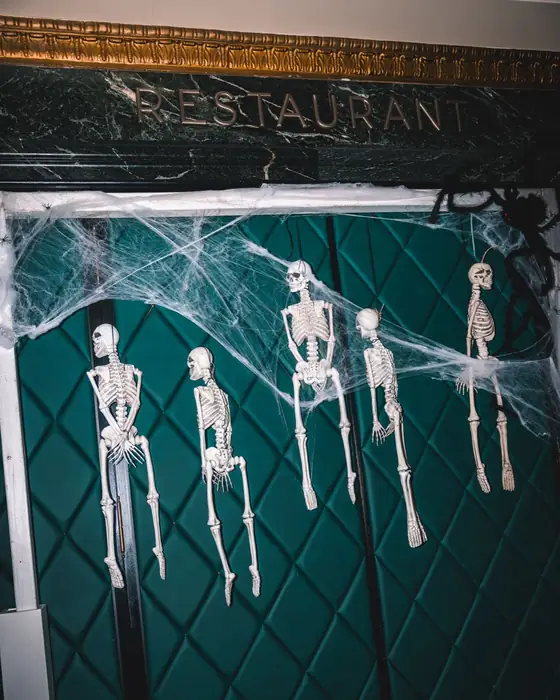 Kleine Skelette und Spinnweben an einer grünen Tür im Wartesaal am Dom bei Spooky Flame