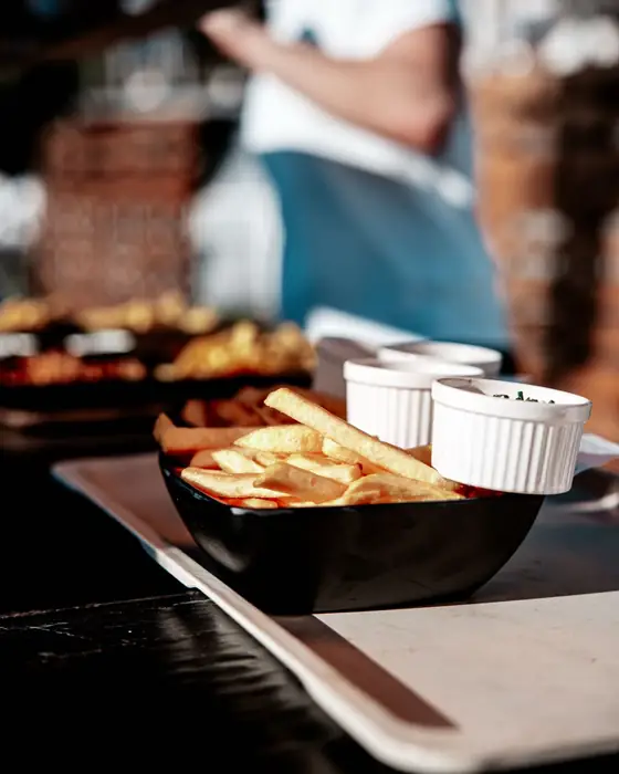 Eine Schale Pommes mit Dips auf einem Tisch beim Golden Flame Open-Air in Köln