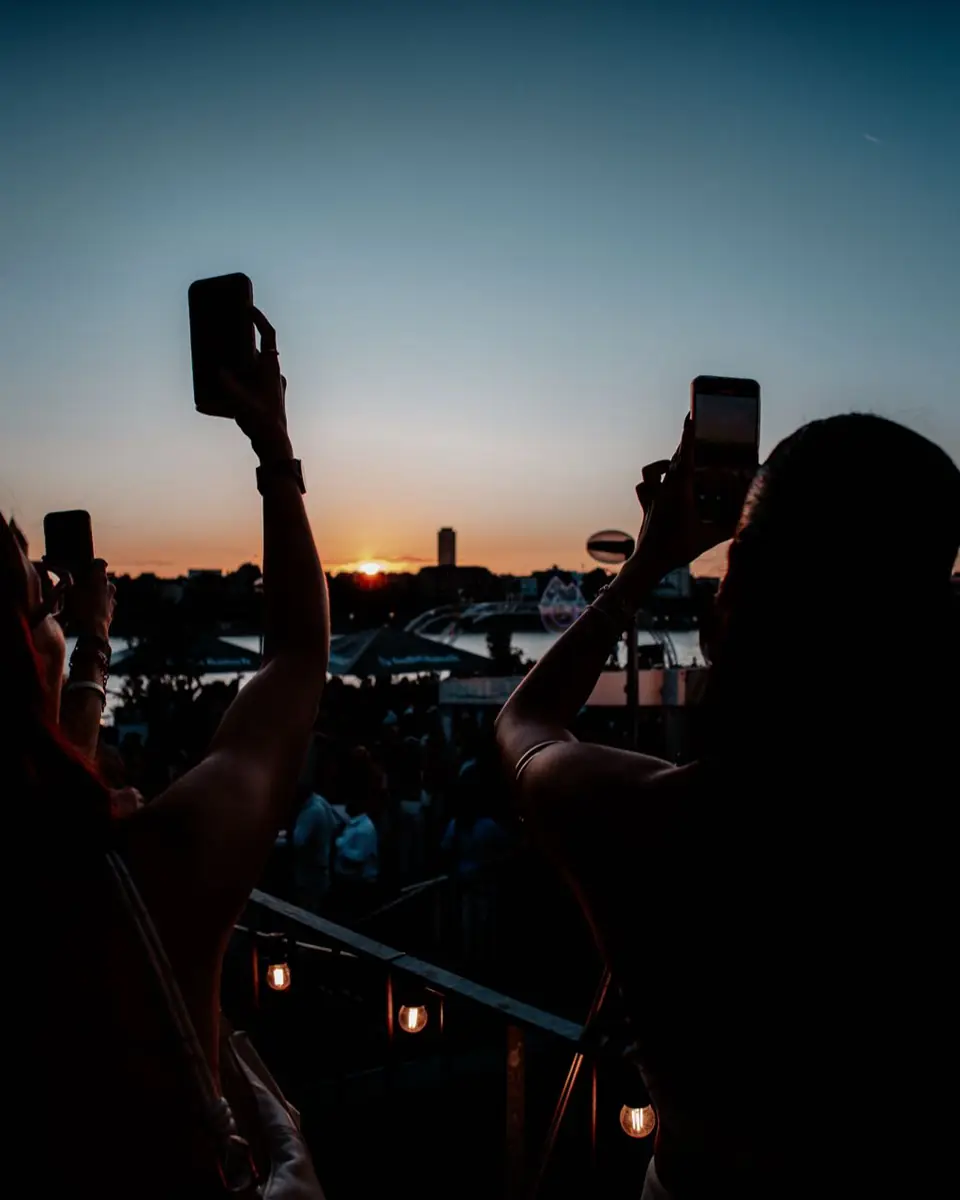Silhouetten fotografieren den Sonnenuntergang mit Handys beim Open Air am Rhein in Köln