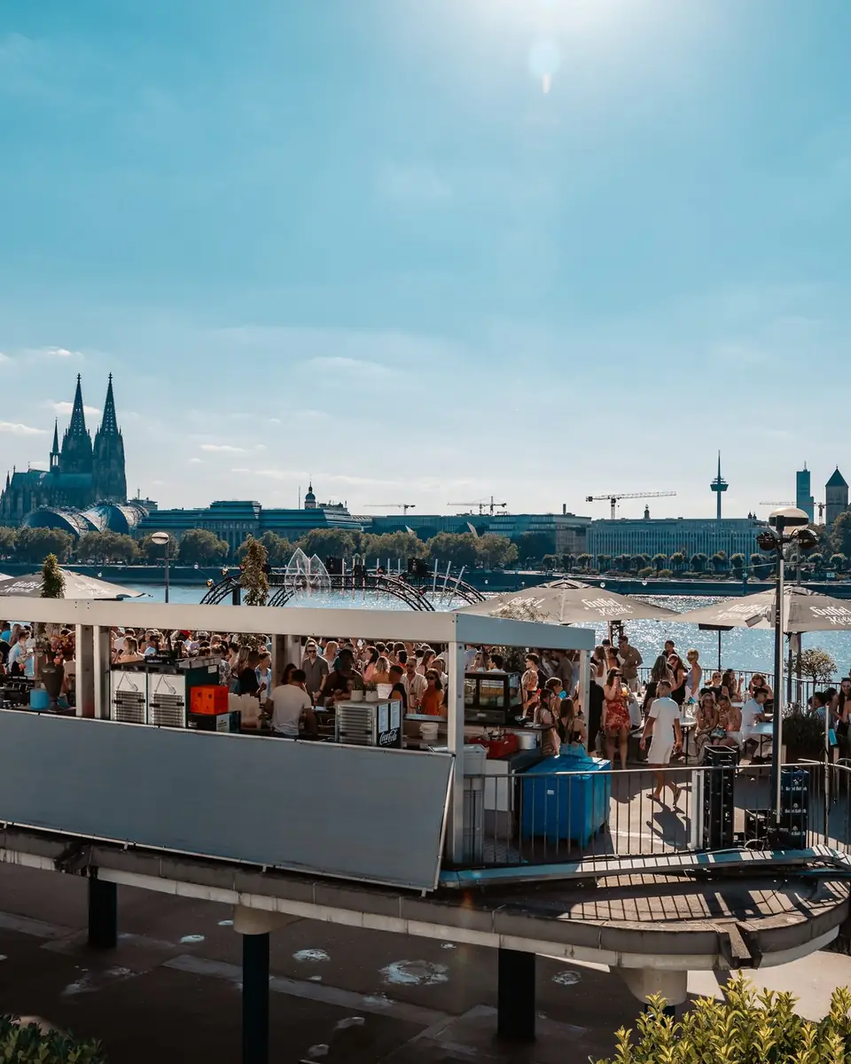 Panorama of the Rheinterrassen in Cologne with the Rhine, the cathedral and the old town skyline during a Golden Flame open air