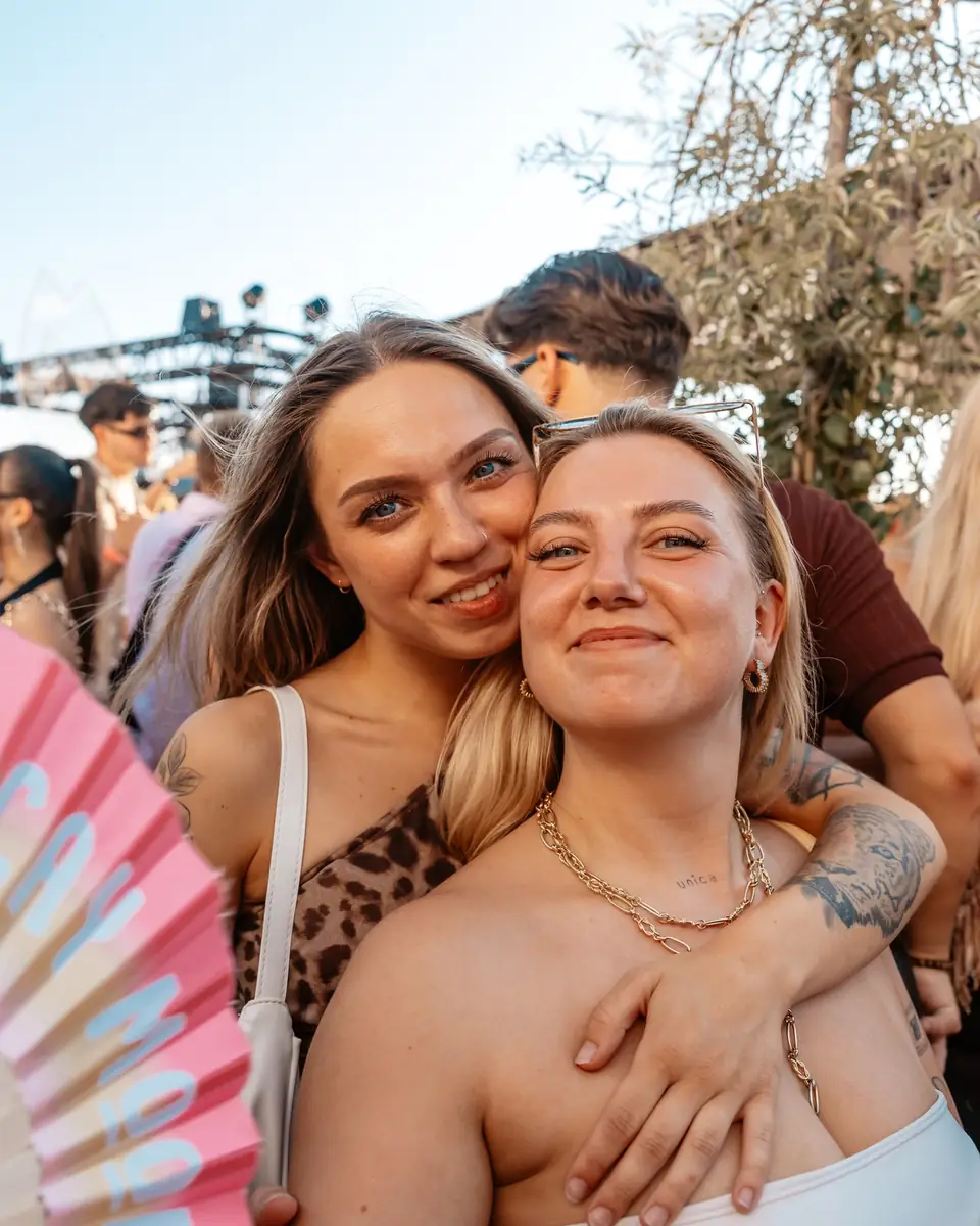 Zwei Freundinnen mit Fächer lachen in die Kamera beim Golden Flame Open-Air in Köln
