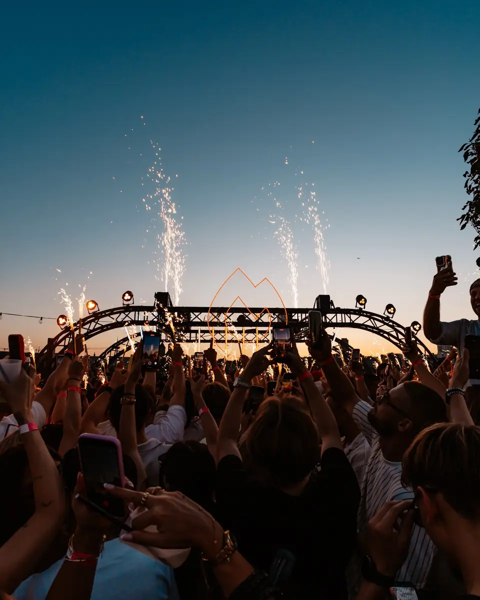 Funkenfontänen und erhobene Hände in der Abenddämmerung beim Golden Flame Open-Air in Köln