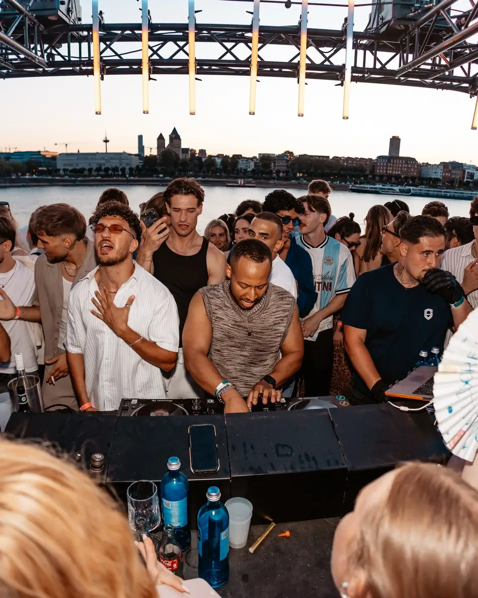 DJ-Pult unter dem Flammen-Bogen, davor tanzt die Crowd beim Golden Flame Open-Air am Rhein in Köln