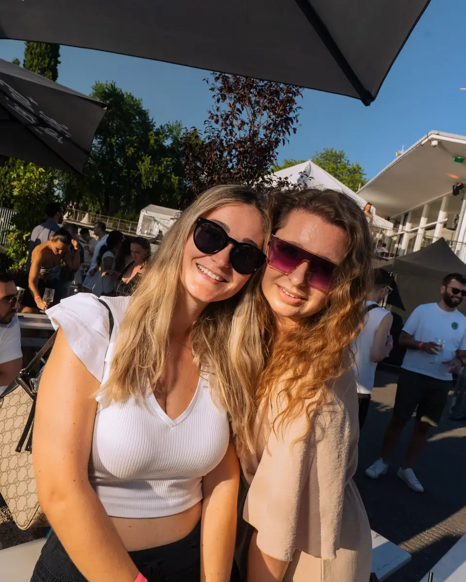 Zwei Freundinnen mit Sonnenbrillen umarmen sich beim Golden Flame Open-Air in Köln