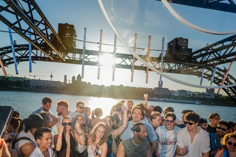 DJ-Pult unter dem Bühnenbogen, davor die Crowd mit erhobenen Händen am Rhein