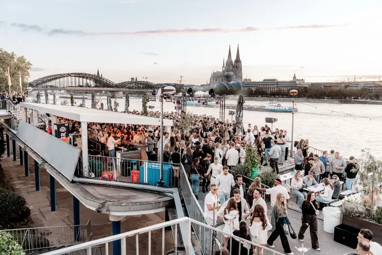 View across the Rheinterrassen to the Hohenzollern Bridge, the Rhine and Cologne Cathedral in the evening