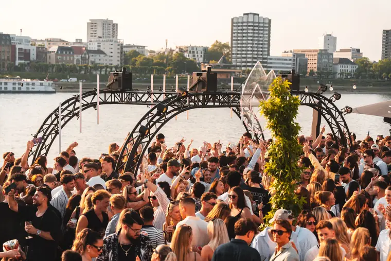 Crowd unter dem Bühnenbogen am Rhein mit Kölner Skyline beim Golden Flame Summer Opening