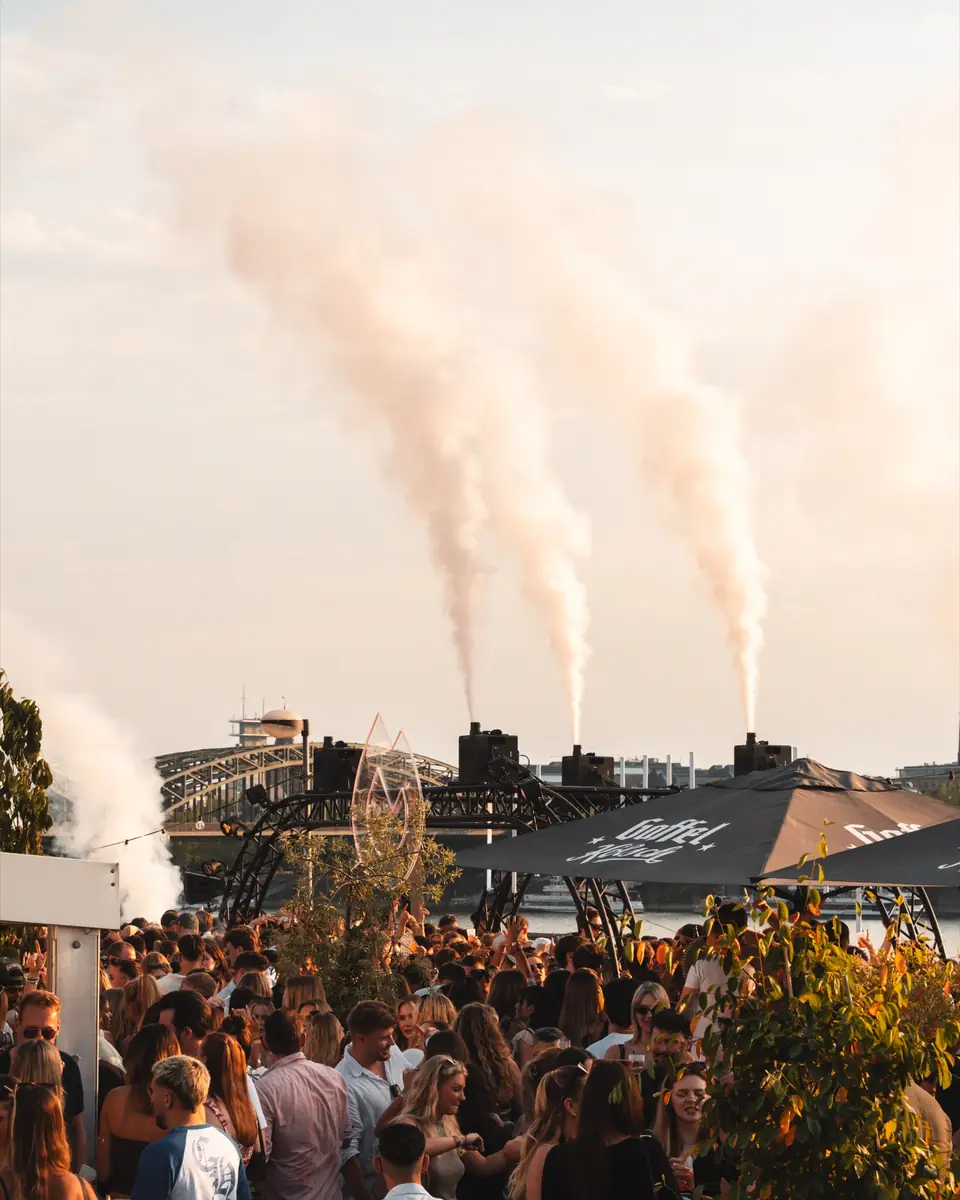 Nebelfontänen am Himmel über der Crowd am Rhein beim Golden Flame Summer Opening