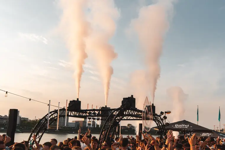 Nebelfontänen über der tanzenden Crowd am Rhein im Abendhimmel beim Summer Opening