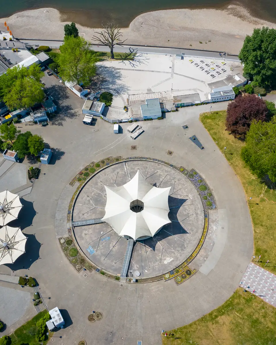 Luftbild des Tanzbrunnen Köln mit dem weißen Sternwellenzelt von Frei Otto, sechs Schirmen und dem Rheinufer