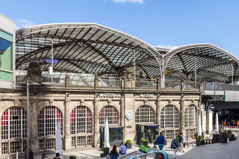 Fassade des Wartesaal am Dom im Kölner Hauptbahnhof mit Schriftzug, darüber das Glasdach der Bahnhofshalle