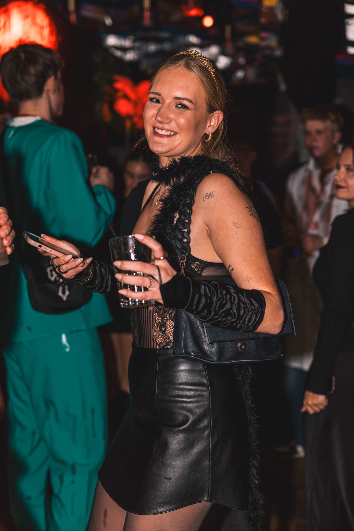 Frau in Lederrock, Spitze und Federboa bei der Spooky Flame Halloween-Party in Köln