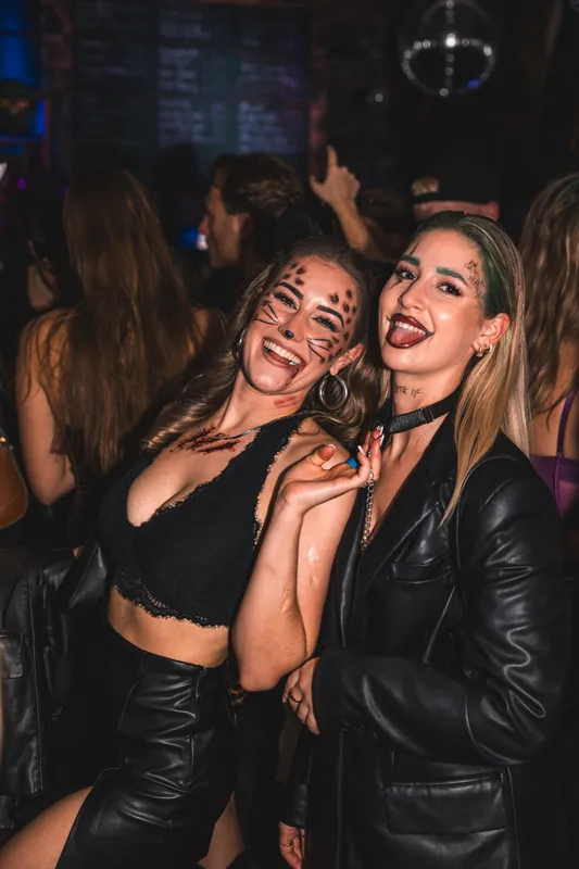 Zwei Freundinnen in Schwarz, eine mit gezeichneten Leo-Flecken im Gesicht, bei Spooky Flame 2024 in Köln