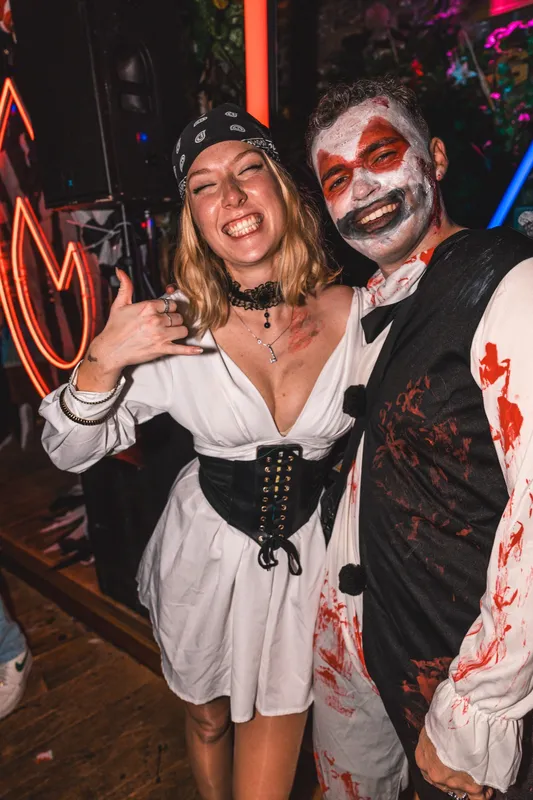 Paar-Kostüm an Halloween in Köln: Piratin und Horror-Clown vor der Neon-Flamme bei Spooky Flame im Goldfinger Club