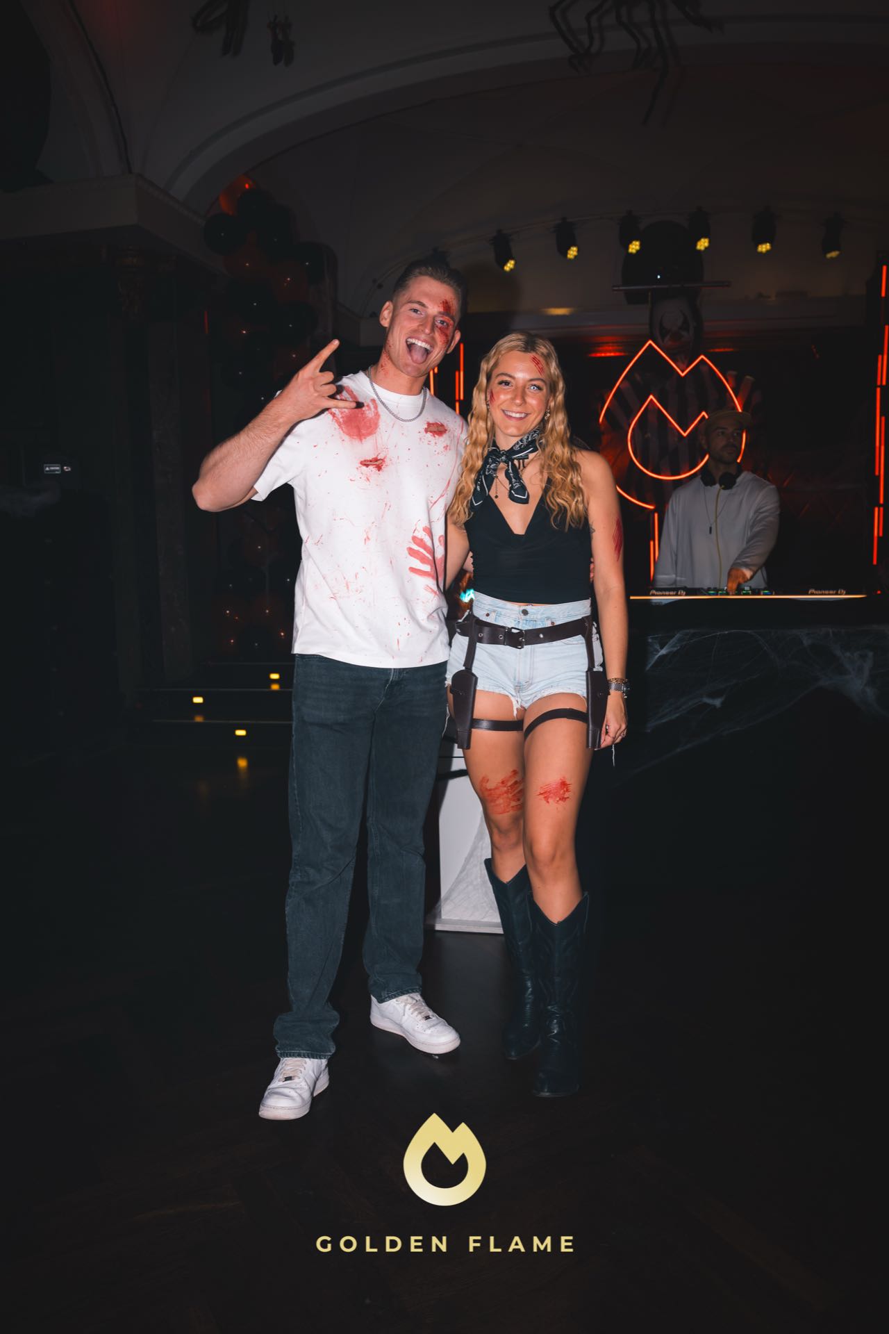Paar bei der Halloween-Party: weißes Shirt mit Kunstblut und Cowboy-Look mit Boots, Spooky Flame Köln