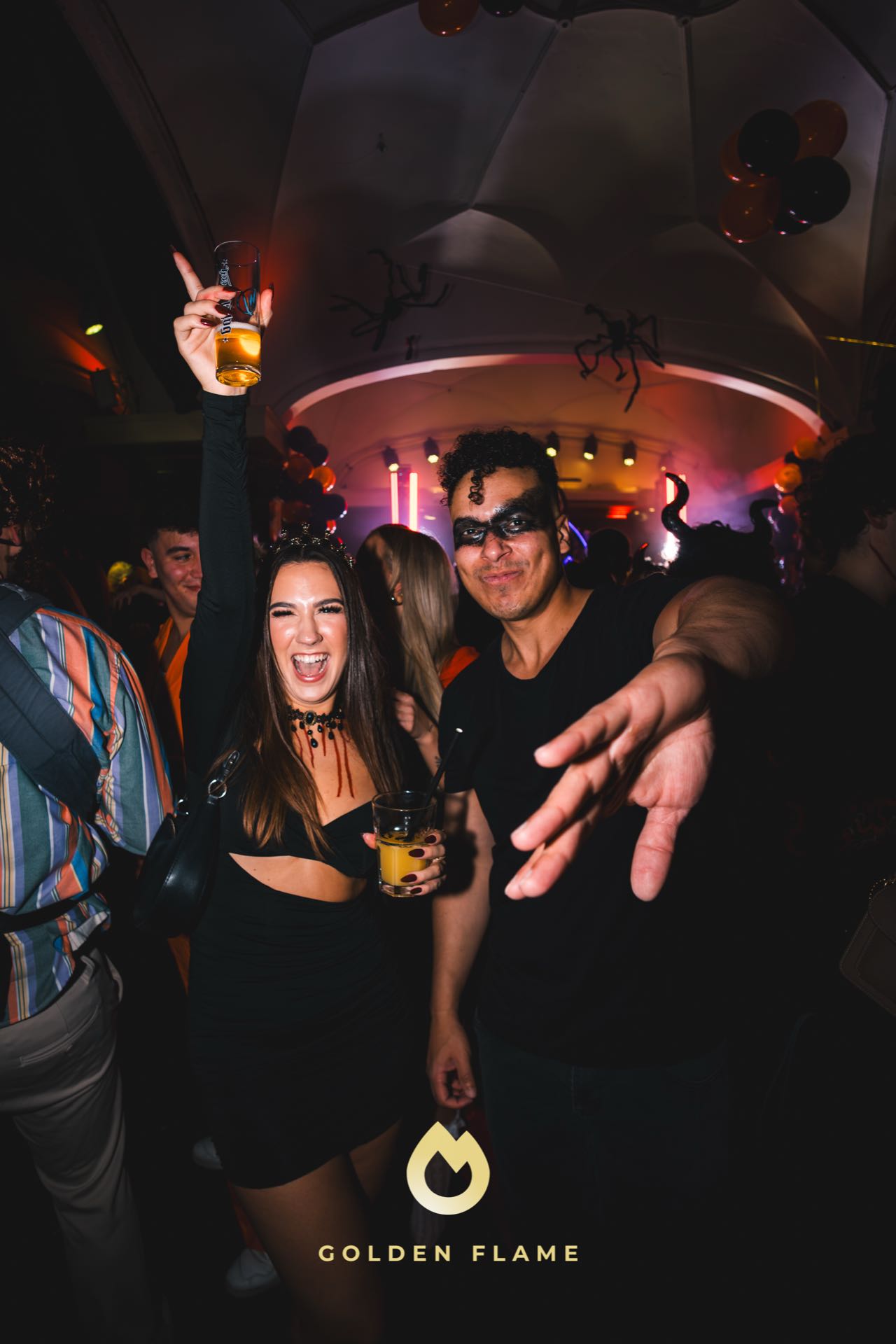 Frau im schwarzen Zweiteiler und Mann mit Maske tanzen bei der Spooky Flame Halloween-Party in Köln