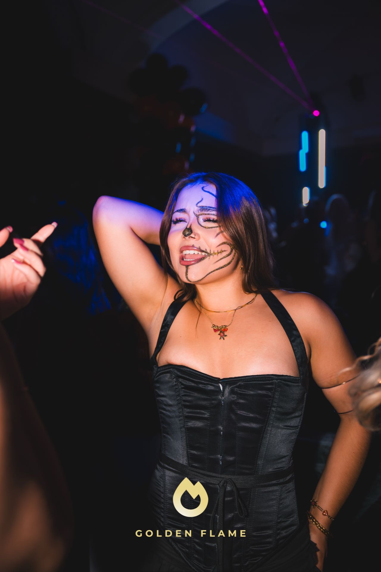 Halloween-Make-up statt Maske: gezeichnete Skelett-Linien zu schwarzer Corsage bei der Halloween-Party in Köln