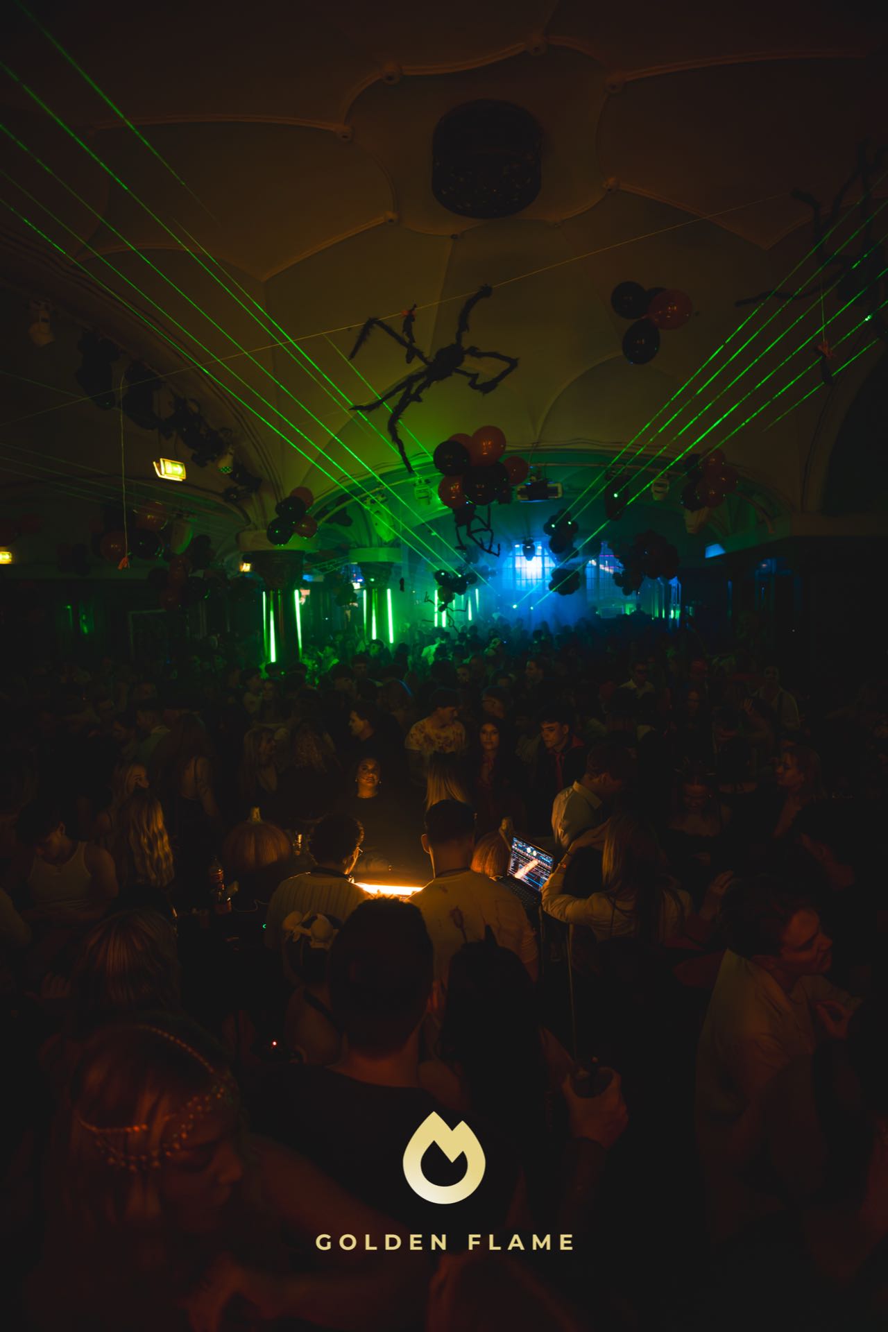 Grüne Laser und Riesenspinnen-Deko über der vollen Tanzfläche bei Spooky Flame in Köln