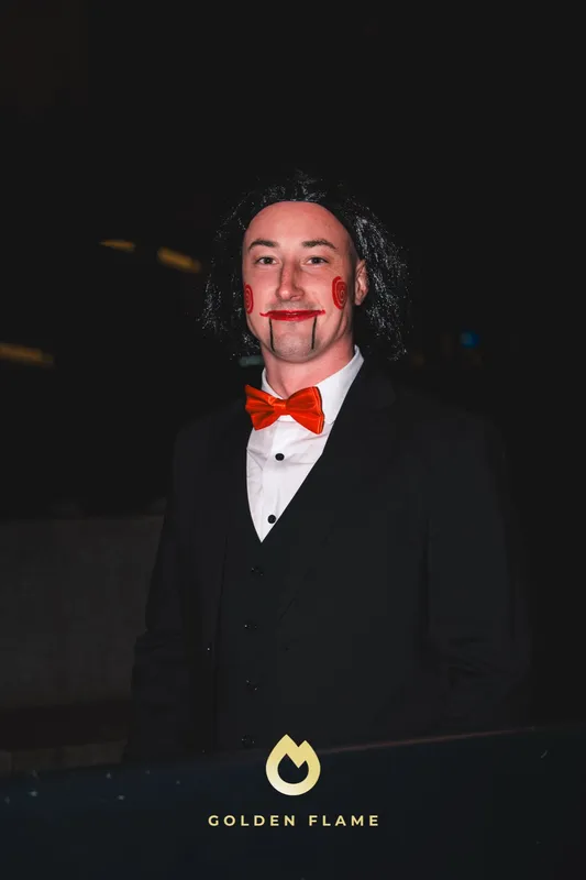 Halloween-Kostüm für Männer: dunkler Anzug mit roter Fliege und Film-Make-up bei Spooky Flame in Köln