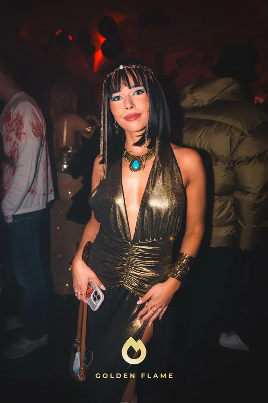 Frau als Kleopatra mit schwarzem Bob, Pony und goldenem Kleid bei Spooky Flame in Köln