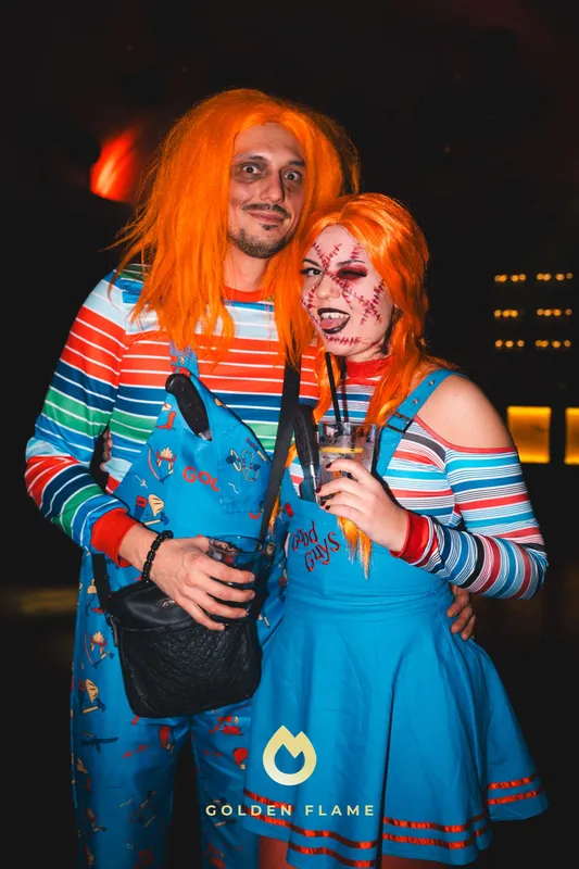Paar im Partnerlook als Chucky mit orangener Perücke, Ringelshirt und blauer Latzhose bei Spooky Flame in Köln