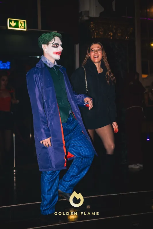 Mann als Joker mit lila Mantel, grünem Haar und weißem Gesicht bei Spooky Flame im Wartesaal am Dom