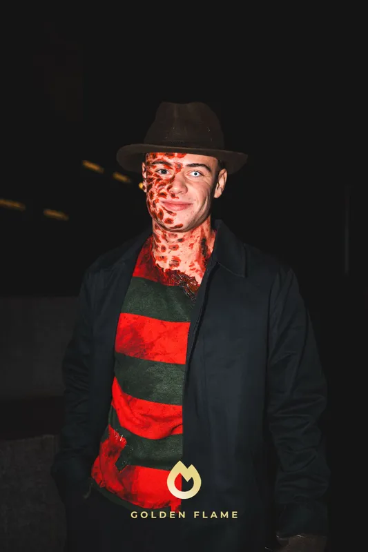 Mann als Freddy Krueger mit rot-grün gestreiftem Pulli, Hut und Narben-Make-up bei Spooky Flame in Köln