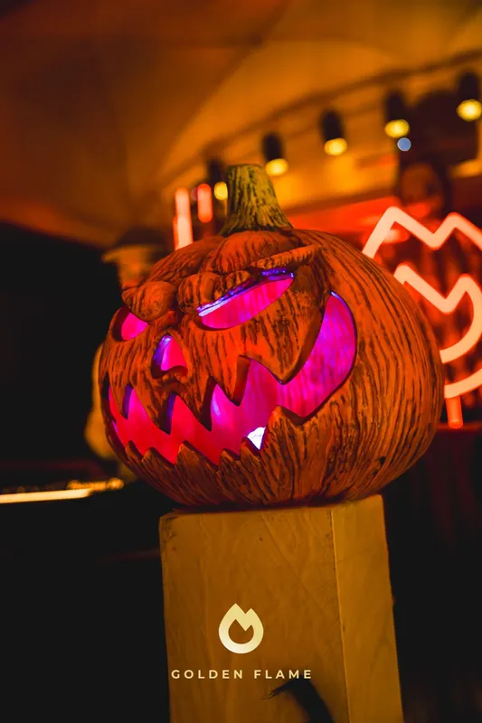 Leuchtender geschnitzter Kürbis vor der orangenen Neon-Flamme bei der Halloween-Nacht Spooky Flame in Köln
