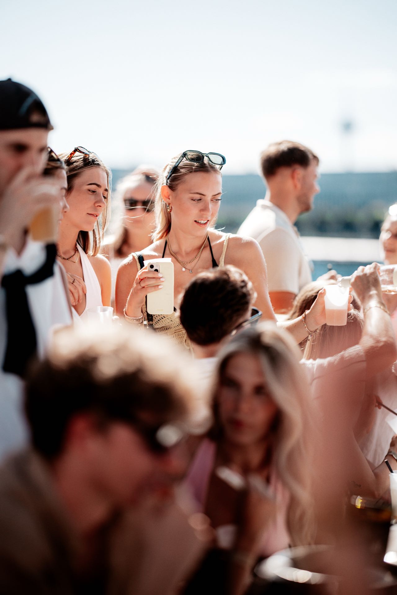 Frau fotografiert mit dem Handy in der Nachmittagssonne beim Golden Flame Open-Air an den Rheinterrassen Köln