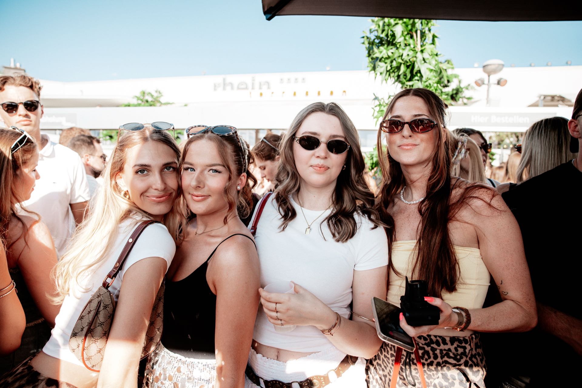 Vier Freundinnen mit Sofortbildkamera beim Golden Flame Open Air an den Rheinterrassen Köln