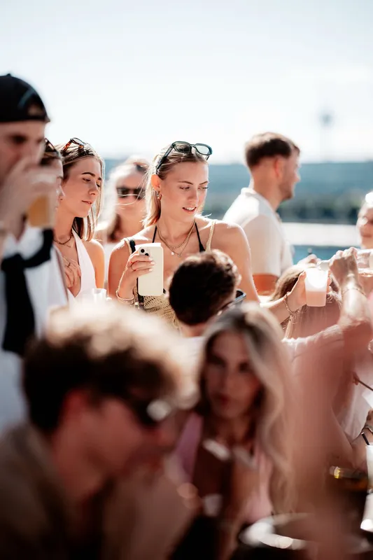 Frau fotografiert mit dem Handy in der Nachmittagssonne beim Golden Flame Open-Air an den Rheinterrassen Köln