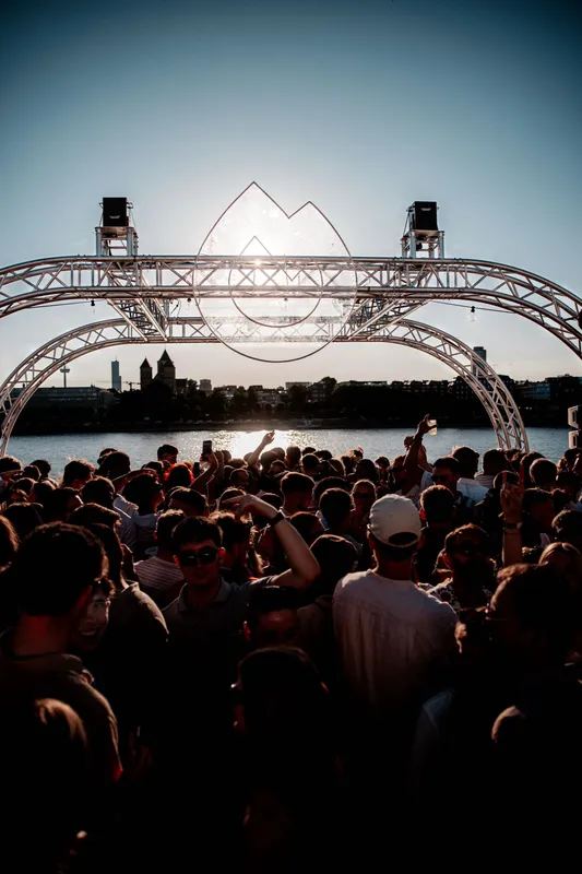 Bühnenbogen im Gegenlicht der Abendsonne, davor die Crowd als Silhouetten
