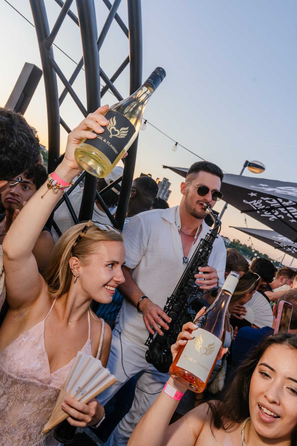 Saxophonist spielt zur goldenen Stunde zwischen den Gästen beim Golden Flame Open-Air an den Rheinterrassen