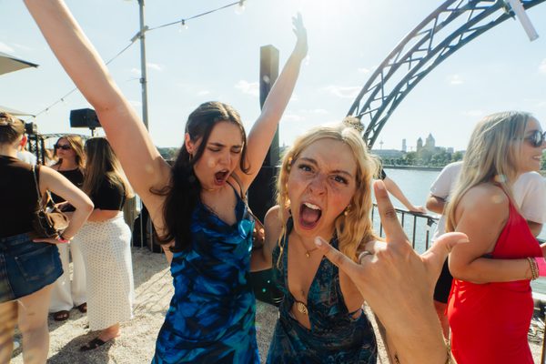 Zwei Freundinnen tanzen ausgelassen beim Golden Flame Open-Air an den Rheinterrassen Köln