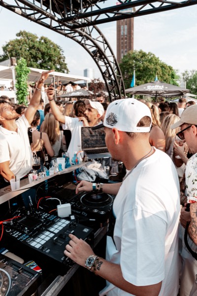 DJ und Crowd in der Sonne beim Golden Flame Summer Opening an den Rheinterrassen Köln