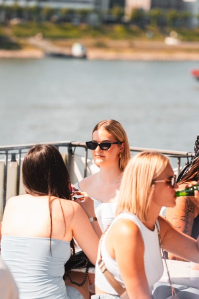 Freundinnen mit Sonnenbrillen direkt am Rheinufer beim Open-Air in Köln