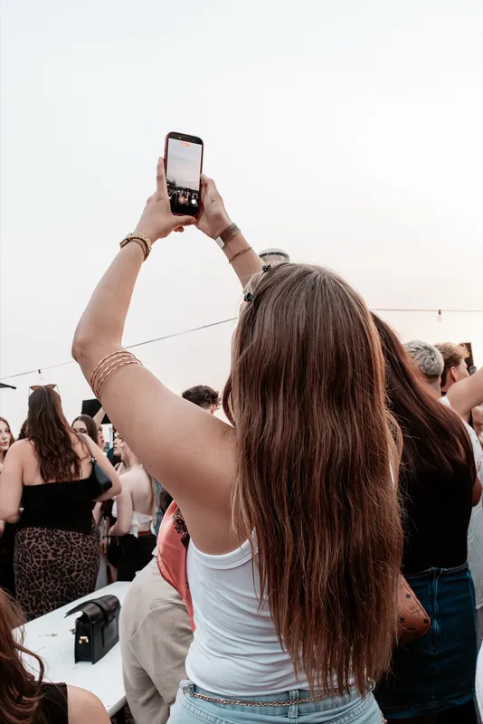 Frau von hinten fotografiert mit erhobenem Handy die Crowd beim Golden Flame Summer Opening