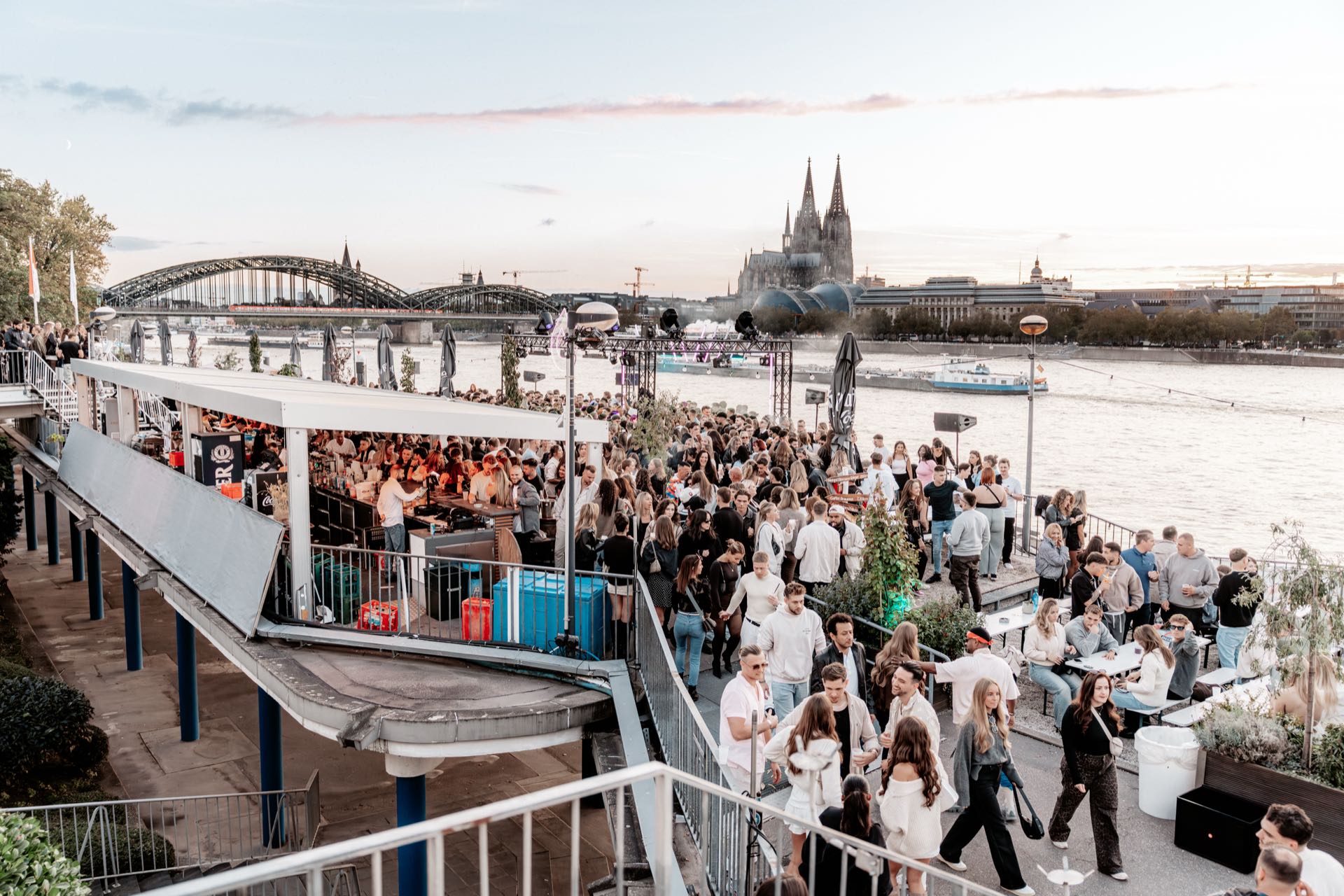 Blick von oben über die Rheinterrassen auf Kölner Dom und Hohenzollernbrücke zur goldenen Stunde